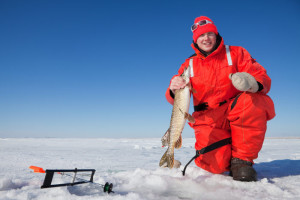 Ice fisherman in Powderhorn Village holding a pike, winter activity.