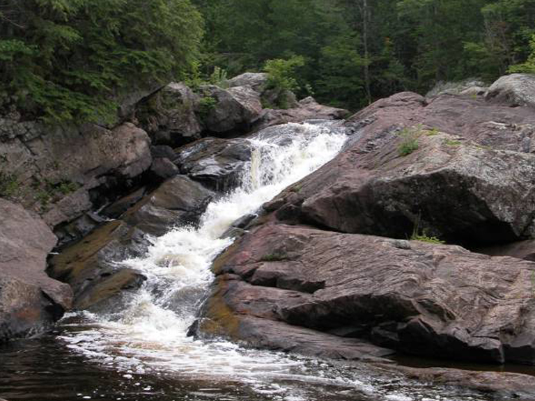 Scenic waterfall cascading over rocks in the Upper Peninsula. Waterfalls near Big Powderhorn Mountain.
