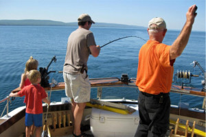 Family fishing on a boat in the Upper Peninsula; water activities near Big Powderhorn.