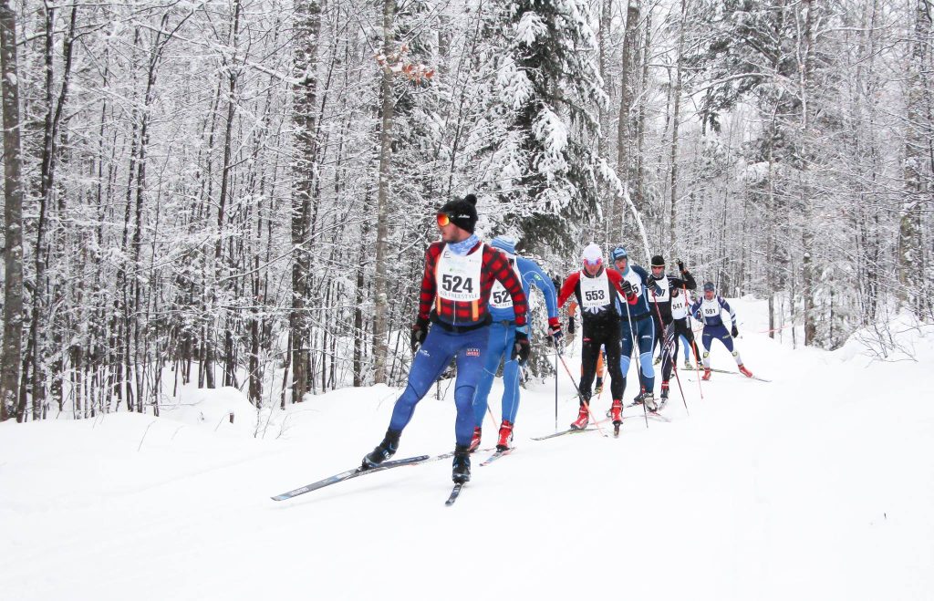Cross-country skiers racing in a snowy forest, Powderhorn Village vacation