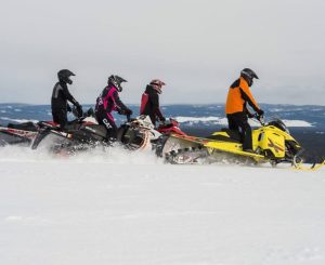 Snowmobilers enjoying winter fun in the snow near Big Powderhorn Mountain.