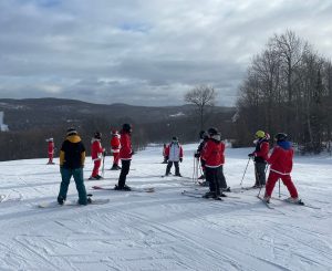 Group skiing and snowboarding at Big Powderhorn Mountain, a fun winter activity.