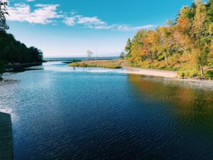 River flowing into Lake Superior with vibrant fall colors near Big Powderhorn Mountain.