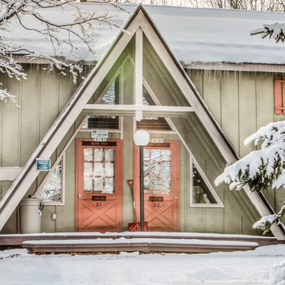 Snowy A-frame building with doors labeled 