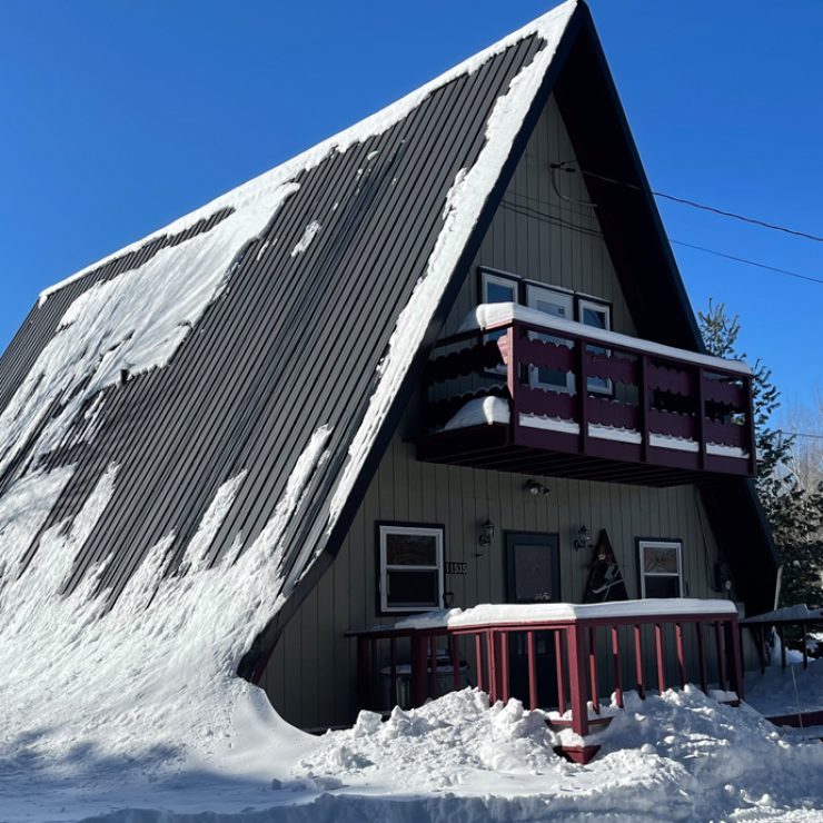 A-frame house covered in snow, showcasing 