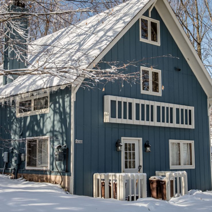 Snow-covered mountain house with icicles. Winter scene.