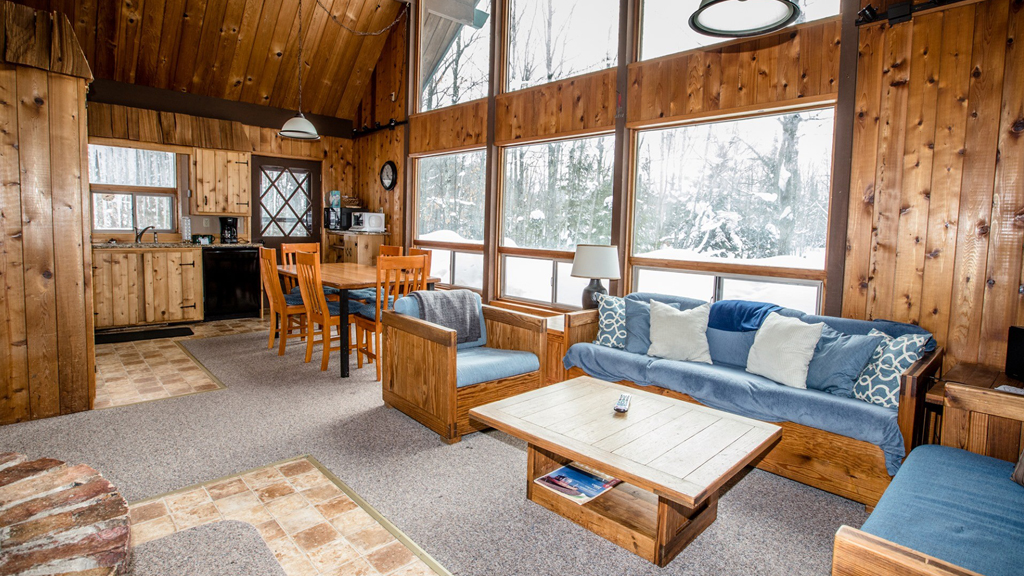 Cozy log cabin living room with fireplace, perfect for Upper Peninsula winter activities.