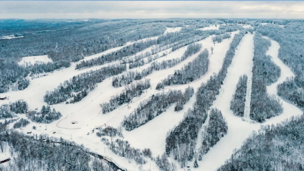 Snowy ski slopes and trees at a ski area near Big Powderhorn Lodging.