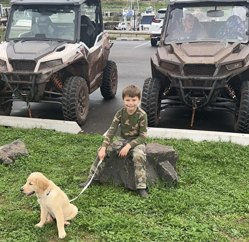 Boy with puppy near ATVs on trails near Big Powderhorn Mountain